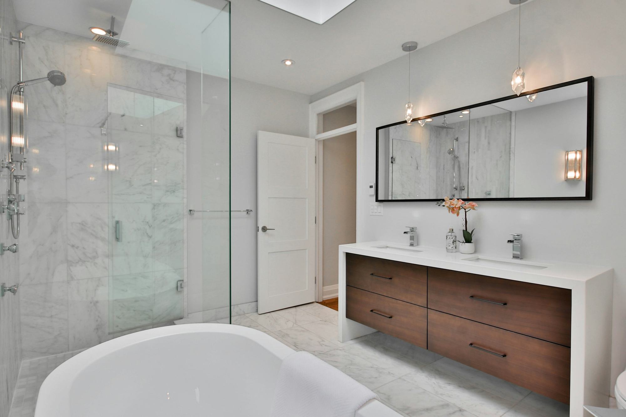 Salle de bains lumineuse avec douche vitrée et faïence claire