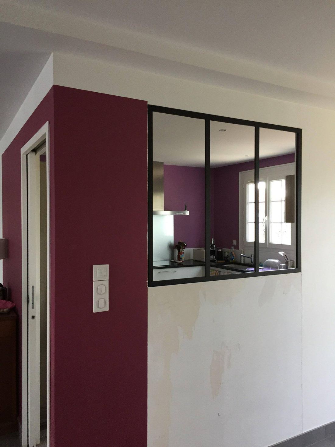 Mur prune et verrière noire dans un intérieur rénové