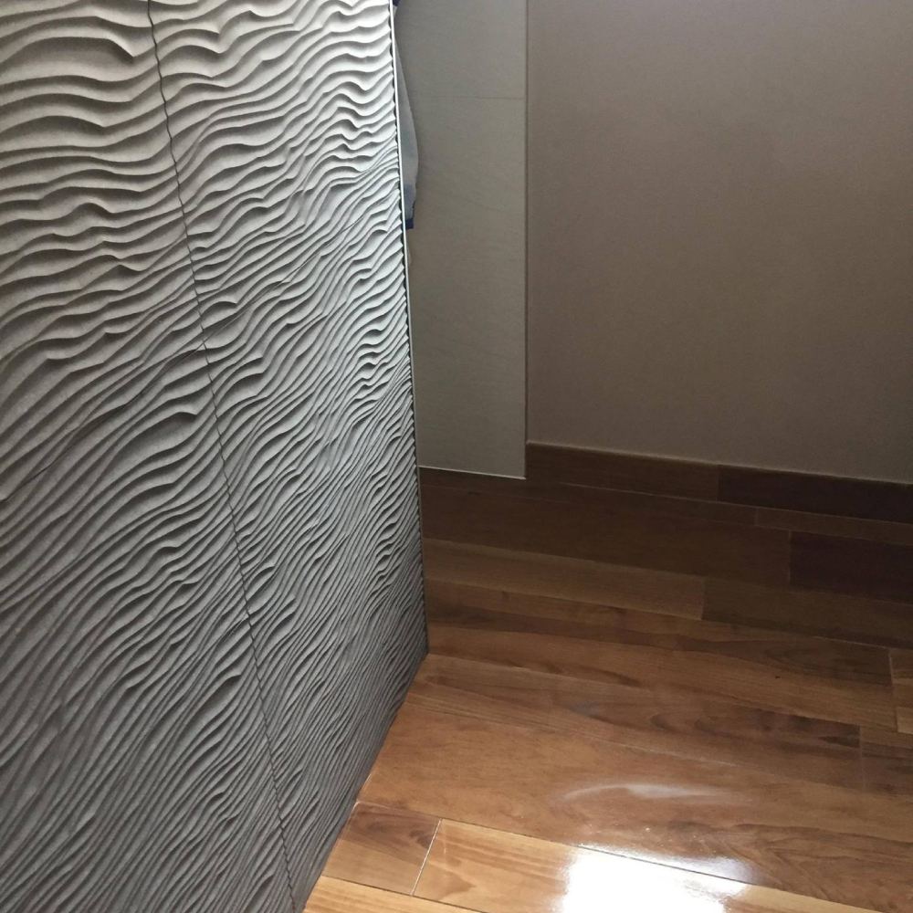 Faïence en relief à vagues posée, au-dessus d'un parquet