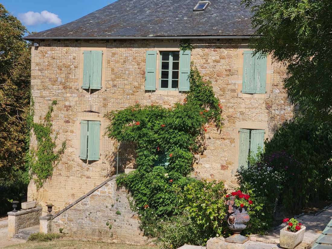 Maison ancienne en pierre aux volets verts