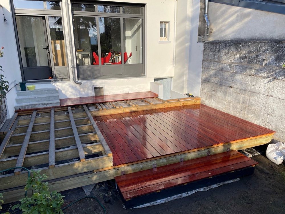 Terrasse en cours de pose : structure réglée et premières lames en bois exotique
