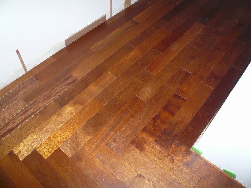 Parquet en bois massif en cours de finition dans une chambre