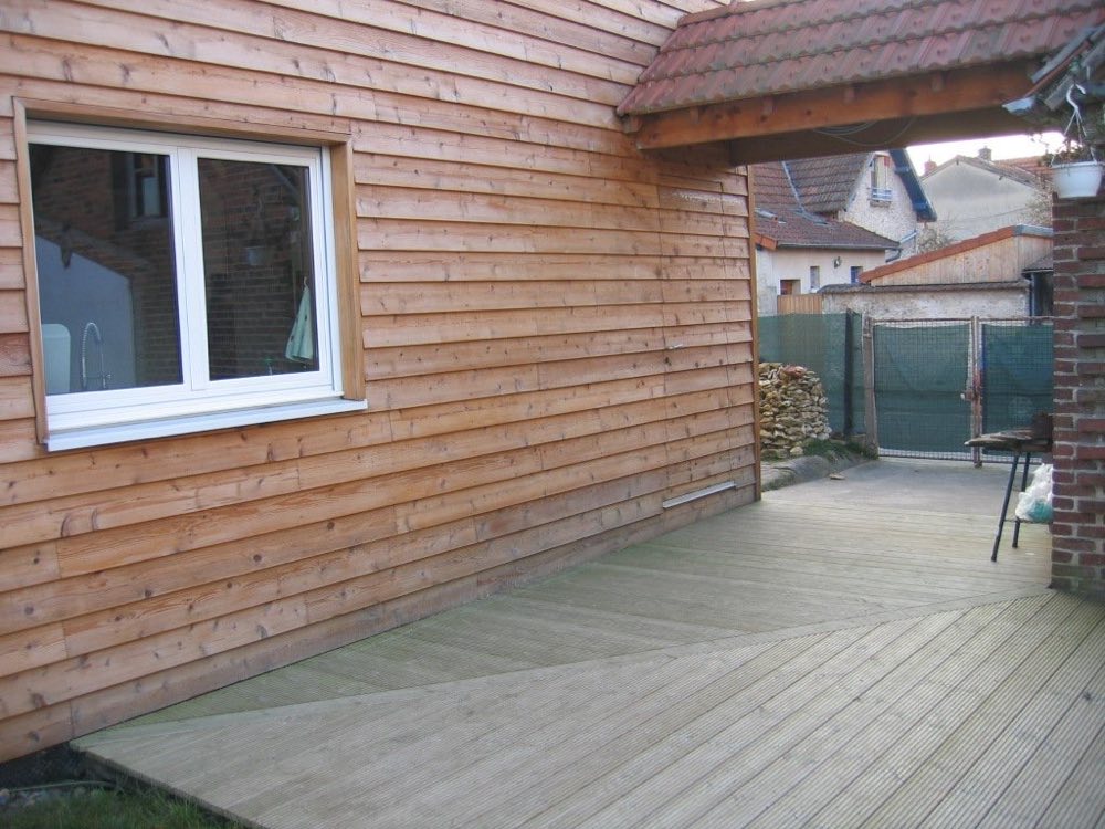 Terrasse posée le long d'une façade en bardage bois